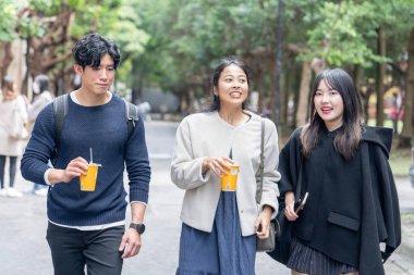 Tayvan 'ın Taipei şehrinde Da' an Bölgesi 'ndeki bir üniversitede konuşan üç üniversite öğrencisi.