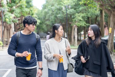 Tayvan 'ın Taipei şehrinde Da' an Bölgesi 'ndeki bir üniversitede konuşan üç üniversite öğrencisi.