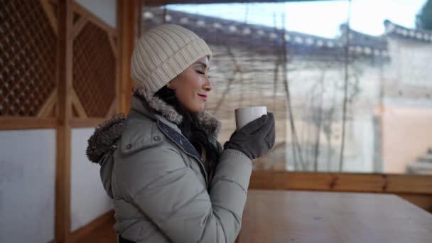 20代のフィリピン人女性のスローモーションビデオは 韓国ソウルの北村ハノック村で伝統的な町でお茶を飲んだ後に休憩を取ります — ストック動画
