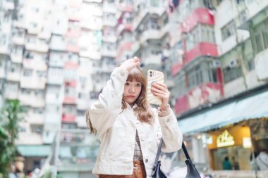 20 'li yaşlarda Çinli bir kadın Hong Kong' da bir parkta mola veriyor.