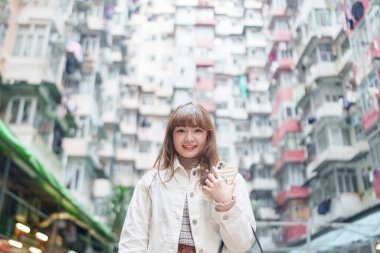 20 'li yaşlarda Çinli bir kadın Hong Kong' da bir parkta mola veriyor.