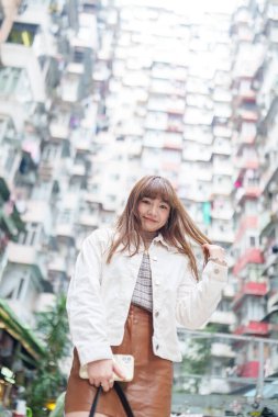 20 'li yaşlarda Çinli bir kadın Hong Kong' da bir parkta mola veriyor.