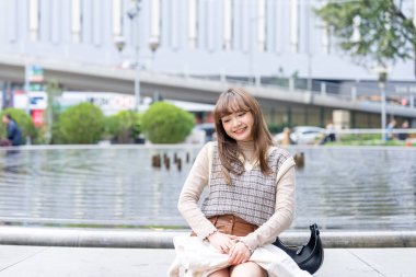 20 'li yaşlarda Çinli bir kadın Hong Kong' da bir parkta mola veriyor.