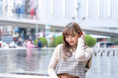 20 'li yaşlarda Çinli bir kadın Hong Kong' da bir parkta mola veriyor.