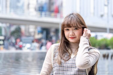 20 'li yaşlarda Çinli bir kadın Hong Kong' da bir parkta mola veriyor.