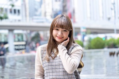 20 'li yaşlarda Çinli bir kadın Hong Kong' da bir parkta mola veriyor.