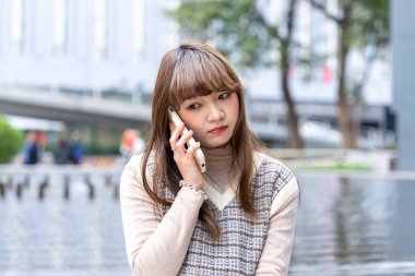 20 'li yaşlarda Çinli bir kadın Hong Kong' da bir parkta mola veriyor.