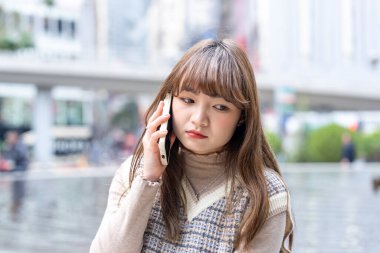 20 'li yaşlarda Çinli bir kadın Hong Kong' da bir parkta mola veriyor.