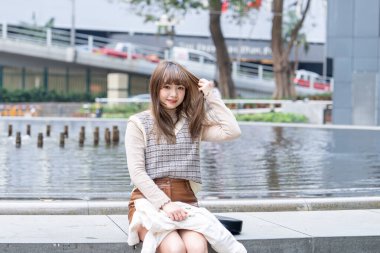 20 'li yaşlarda Çinli bir kadın Hong Kong' da bir parkta mola veriyor.