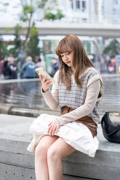 20 'li yaşlarda Çinli bir kadın Hong Kong' da bir parkta mola veriyor.