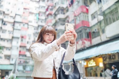 20 'li yaşlarda Çinli bir kadın Hong Kong' da bir parkta mola veriyor.