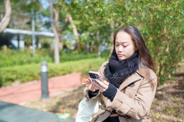 20 'li yaşlarda Çinli bir kadın Hong Kong' da bir parkta mola veriyor.