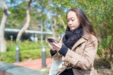20 'li yaşlarda Çinli bir kadın Hong Kong' da bir parkta mola veriyor.
