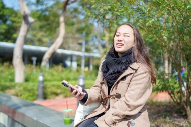 20 'li yaşlarda Çinli bir kadın Hong Kong' da bir parkta mola veriyor.