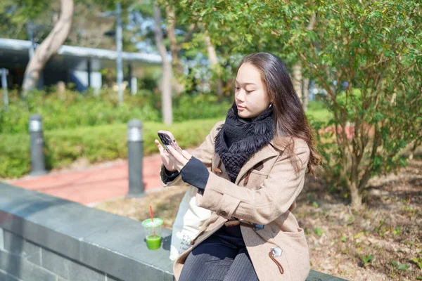 20 'li yaşlarda Çinli bir kadın Hong Kong' da bir parkta mola veriyor.