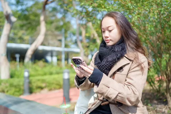 20 'li yaşlarda Çinli bir kadın Hong Kong' da bir parkta mola veriyor.