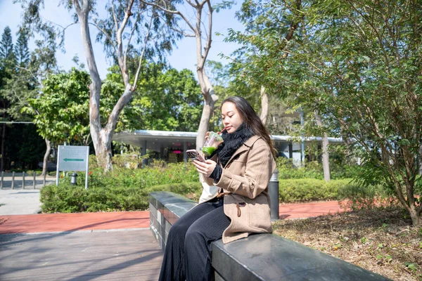 20 'li yaşlarda Çinli bir kadın Hong Kong' da bir parkta mola veriyor.