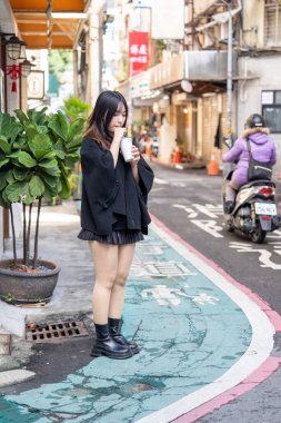 Tayvan 'ın Taipei şehrindeki Zhongshan İstasyonunda 20' li yaşlarda genç bir Tayvanlı kadın tapyoka içiyor.