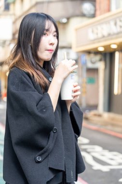 Tayvan 'ın Taipei şehrindeki Zhongshan İstasyonunda 20' li yaşlarda genç bir Tayvanlı kadın tapyoka içiyor.