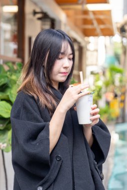 Tayvan 'ın Taipei şehrindeki Zhongshan İstasyonunda 20' li yaşlarda genç bir Tayvanlı kadın tapyoka içiyor.