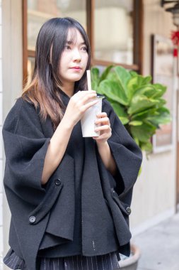 Tayvan 'ın Taipei şehrindeki Zhongshan İstasyonunda 20' li yaşlarda genç bir Tayvanlı kadın tapyoka içiyor.