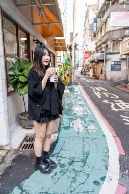 Tayvan 'ın Taipei şehrindeki Zhongshan İstasyonunda 20' li yaşlarda genç bir Tayvanlı kadın tapyoka içiyor.