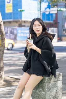 Tayvan 'ın Taipei şehrindeki Zhongshan İstasyonunda 20' li yaşlarda genç bir Tayvanlı kadın tapyoka içiyor.