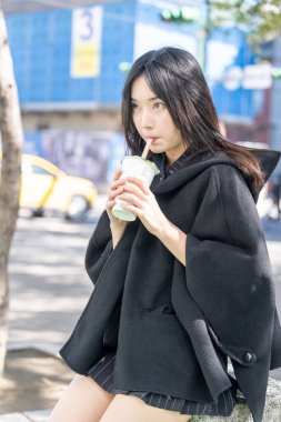 Tayvan 'ın Taipei şehrindeki Zhongshan İstasyonunda 20' li yaşlarda genç bir Tayvanlı kadın tapyoka içiyor.