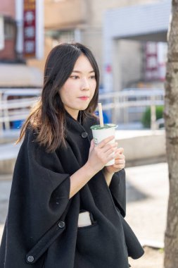 Tayvan 'ın Taipei şehrindeki Zhongshan İstasyonunda 20' li yaşlarda genç bir Tayvanlı kadın tapyoka içiyor.