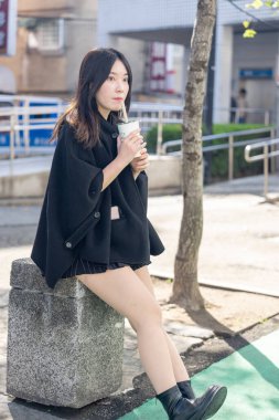 Tayvan 'ın Taipei şehrindeki Zhongshan İstasyonunda 20' li yaşlarda genç bir Tayvanlı kadın tapyoka içiyor.