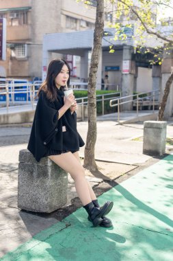 Tayvan 'ın Taipei şehrindeki Zhongshan İstasyonunda 20' li yaşlarda genç bir Tayvanlı kadın tapyoka içiyor.