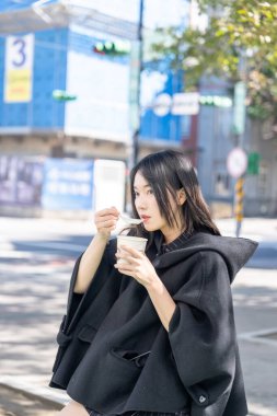 Tayvan 'ın Zhongshan Bölgesi' ndeki Zhongshan İstasyonu 'nda 20' li yaşlarda genç bir Tayvanlı kadın tofu pudingi yiyor.