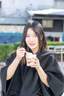 Tayvan 'ın Zhongshan Bölgesi' ndeki Zhongshan İstasyonu 'nda 20' li yaşlarda genç bir Tayvanlı kadın tofu pudingi yiyor.