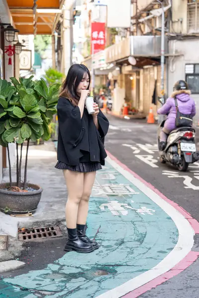 Tayvan 'ın Taipei şehrindeki Zhongshan İstasyonunda 20' li yaşlarda genç bir Tayvanlı kadın tapyoka içiyor.