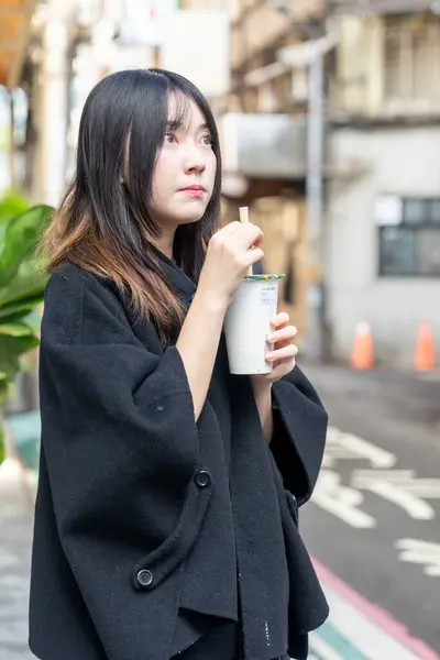 Tayvan 'ın Taipei şehrindeki Zhongshan İstasyonunda 20' li yaşlarda genç bir Tayvanlı kadın tapyoka içiyor.