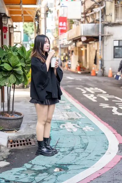 Tayvan 'ın Taipei şehrindeki Zhongshan İstasyonunda 20' li yaşlarda genç bir Tayvanlı kadın tapyoka içiyor.