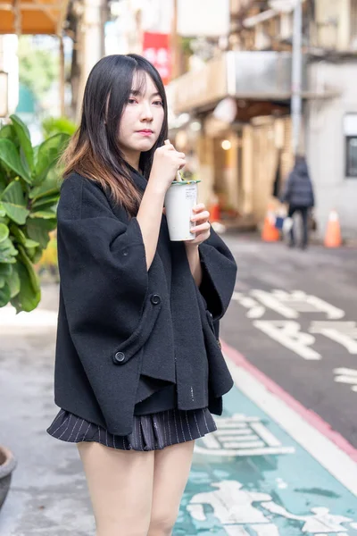 Tayvan 'ın Taipei şehrindeki Zhongshan İstasyonunda 20' li yaşlarda genç bir Tayvanlı kadın tapyoka içiyor.