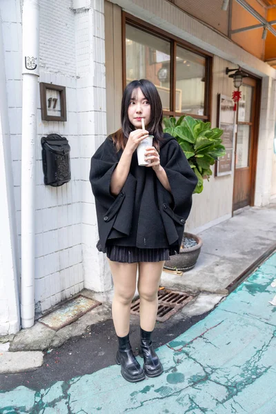 Tayvan 'ın Taipei şehrindeki Zhongshan İstasyonunda 20' li yaşlarda genç bir Tayvanlı kadın tapyoka içiyor.