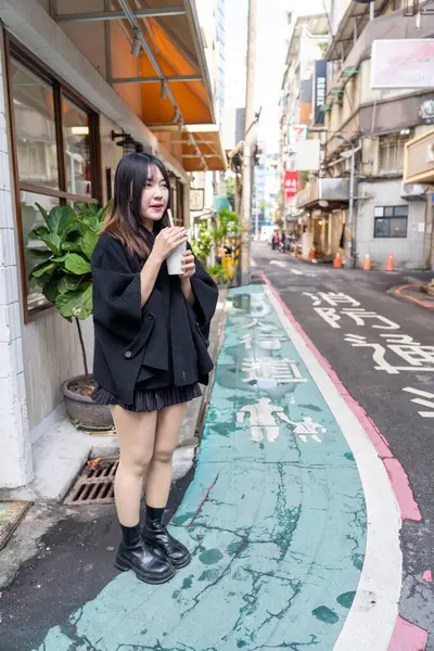 Tayvan 'ın Taipei şehrindeki Zhongshan İstasyonunda 20' li yaşlarda genç bir Tayvanlı kadın tapyoka içiyor.