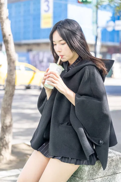 Tayvan 'ın Taipei şehrindeki Zhongshan İstasyonunda 20' li yaşlarda genç bir Tayvanlı kadın tapyoka içiyor.