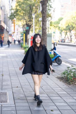 Tayvan 'ın Taipei şehrindeki Zhongshan İstasyonu' nda 20 'li yaşlarda genç bir Tayvanlı kadın yürüyor.