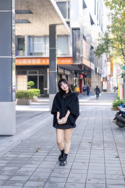 Tayvan 'ın Taipei şehrindeki Zhongshan İstasyonu' nda 20 'li yaşlarda genç bir Tayvanlı kadın yürüyor.