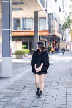 Tayvan 'ın Taipei şehrindeki Zhongshan İstasyonu' nda 20 'li yaşlarda genç bir Tayvanlı kadın yürüyor.