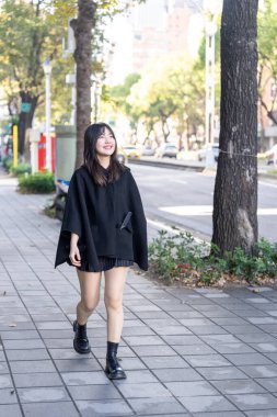 Tayvan 'ın Taipei şehrindeki Zhongshan İstasyonu' nda 20 'li yaşlarda genç bir Tayvanlı kadın yürüyor.