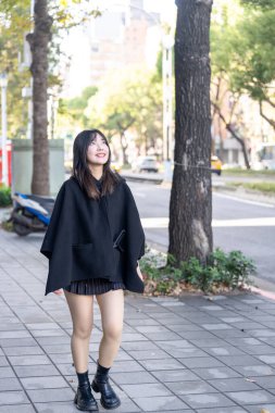 Tayvan 'ın Taipei şehrindeki Zhongshan İstasyonu' nda 20 'li yaşlarda genç bir Tayvanlı kadın yürüyor.