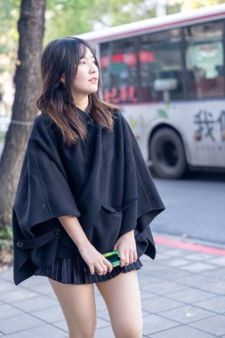 Tayvan 'ın Taipei şehrindeki Zhongshan İstasyonu' nda 20 'li yaşlarda genç bir Tayvanlı kadın yürüyor.