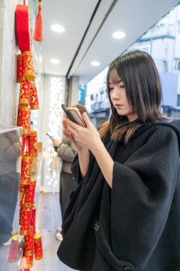 Tayvan 'ın Taipei şehrindeki Zhongshan İstasyonu' nda 20 'li yaşlarda genç bir Tayvanlı kadın yürüyor.