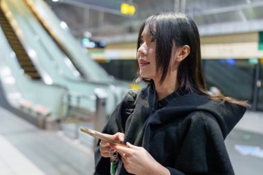 20 'li yaşlarda Tayvanlı genç bir üniversite öğrencisi akıllı telefonunu Taipei, Tayvan' da bir metro istasyonunda ya da trende kullanıyor.