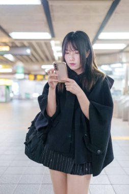 20 'li yaşlarda Tayvanlı genç bir üniversite öğrencisi akıllı telefonunu Taipei, Tayvan' da bir metro istasyonunda ya da trende kullanıyor.