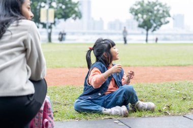 Tayvan 'ın Taipei şehrinde Datong Bölgesi' nde büyük bir parkta oynayan çocuklar ve aileler.